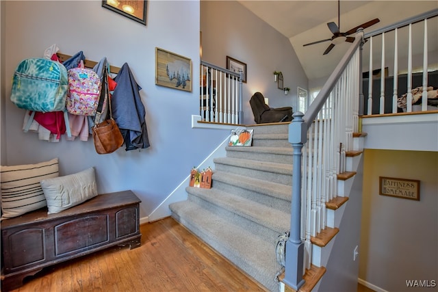 staircase with wood-type flooring, vaulted ceiling, and ceiling fan