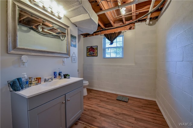 bathroom with hardwood / wood-style floors, vanity, and toilet