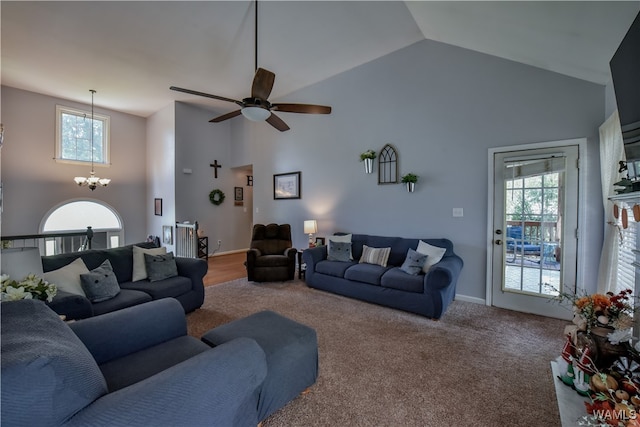 living room with carpet flooring, ceiling fan with notable chandelier, and high vaulted ceiling