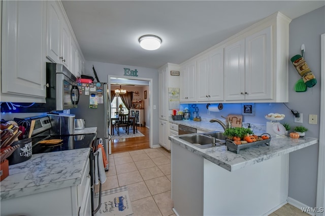 kitchen featuring white cabinetry, sink, kitchen peninsula, light tile patterned floors, and appliances with stainless steel finishes