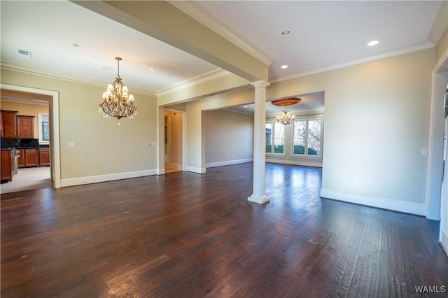 spare room with decorative columns, dark hardwood / wood-style floors, crown molding, and an inviting chandelier