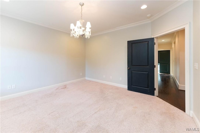 empty room featuring a notable chandelier, carpet flooring, and ornamental molding