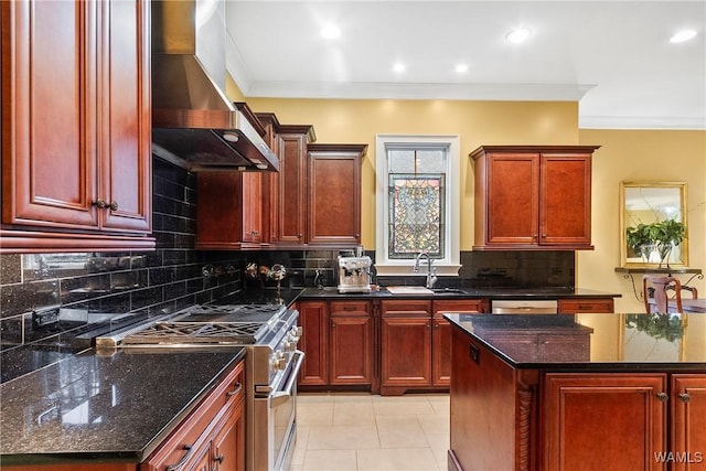 kitchen featuring wall chimney range hood, dark stone countertops, stainless steel appliances, and decorative backsplash