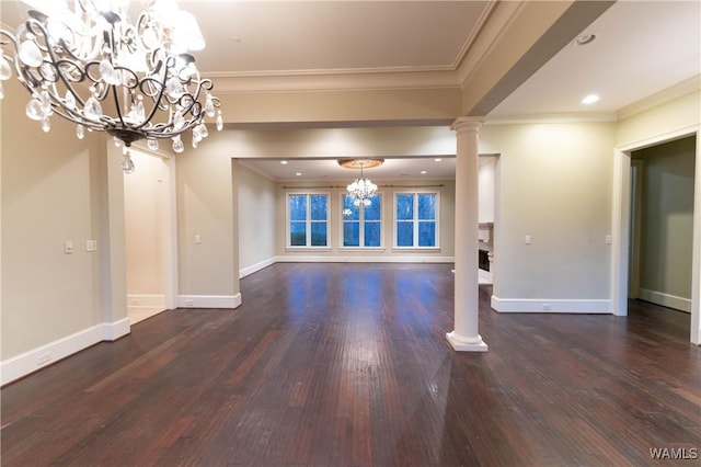 unfurnished living room with decorative columns, an inviting chandelier, dark hardwood / wood-style floors, and crown molding