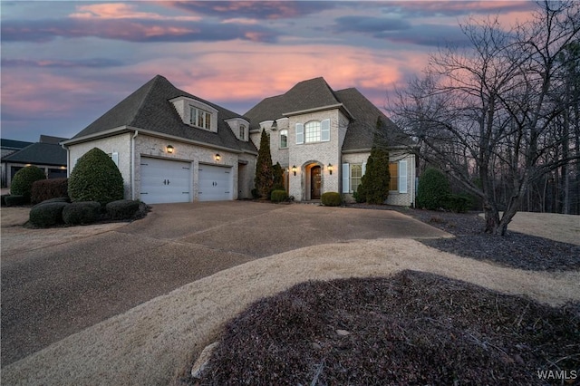 french provincial home with a garage