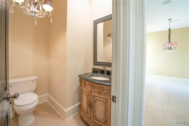 bathroom featuring tile patterned flooring, toilet, vanity, a notable chandelier, and ornamental molding