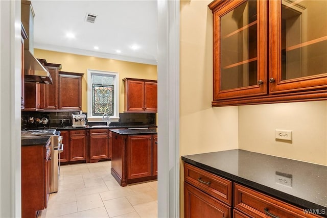 kitchen with tasteful backsplash, sink, ornamental molding, high end stainless steel range oven, and light tile patterned floors