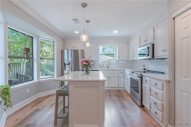 1603 Quail Run Dr, Tuscaloosa, AL 35406 - kitchen with appliances with stainless steel finishes, a sink, white cabinets, backsplash, and ornamental molding