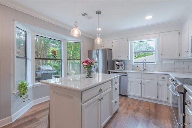 1603 Quail Run Dr, Tuscaloosa, AL 35406 - kitchen with appliances with stainless steel finishes, a sink, ornamental molding, white cabinetry, and light countertops