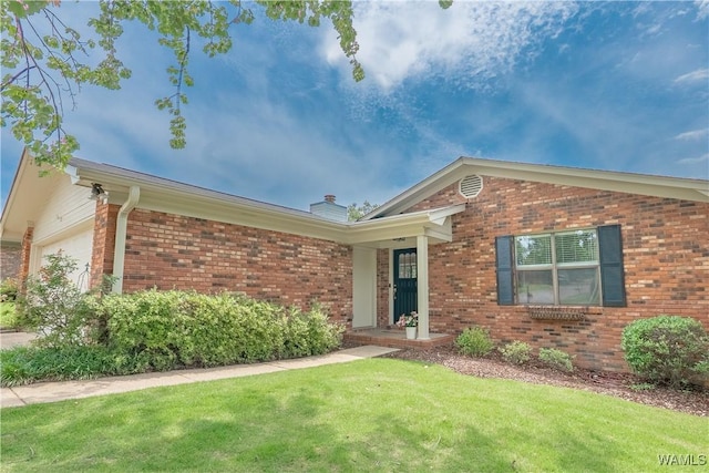 1603 Quail Run Dr, Tuscaloosa, AL 35406 - view of front facade with brick siding, a front yard, a garage, and a chimney