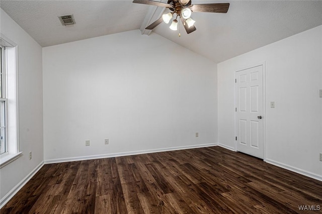 empty room featuring dark wood-type flooring, ceiling fan, lofted ceiling with beams, and a textured ceiling