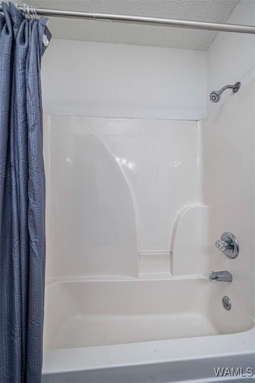 bathroom featuring shower / bath combo with shower curtain and a textured ceiling