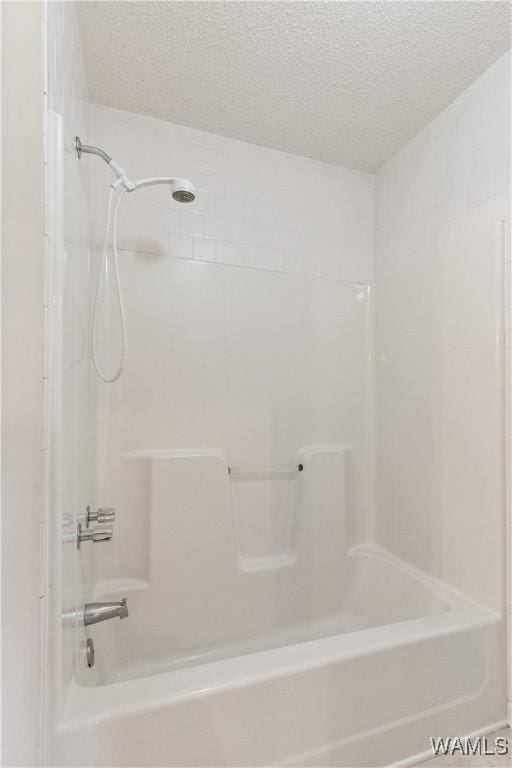 bathroom featuring a textured ceiling and shower / tub combination