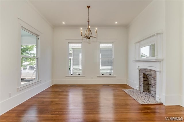 unfurnished living room with wood-type flooring, crown molding, and a chandelier