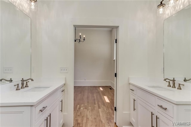 bathroom featuring hardwood / wood-style flooring, vanity, and a chandelier