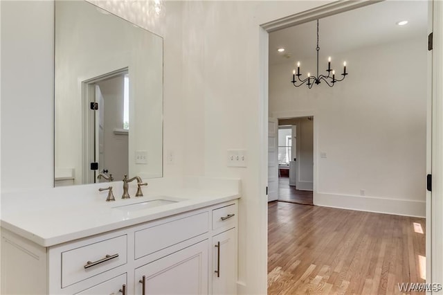 bathroom with vanity, a chandelier, and hardwood / wood-style flooring