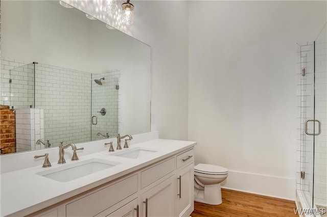 bathroom featuring hardwood / wood-style floors, vanity, toilet, and walk in shower