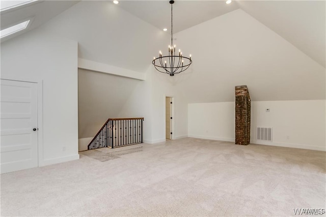 additional living space with a chandelier, lofted ceiling with skylight, and light colored carpet