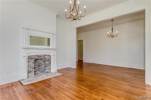 unfurnished living room featuring hardwood / wood-style flooring, ornamental molding, and a chandelier