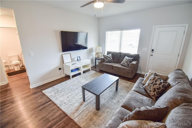 living room with ceiling fan and dark hardwood / wood-style flooring