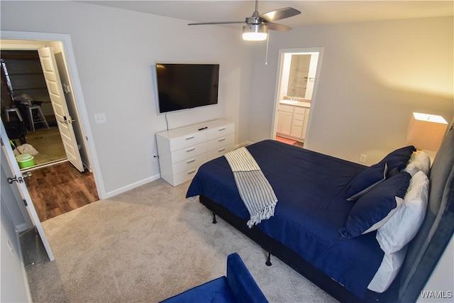 bedroom with ceiling fan, light hardwood / wood-style floors, sink, and ensuite bathroom