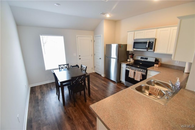 kitchen with white cabinets, dark hardwood / wood-style flooring, sink, and appliances with stainless steel finishes