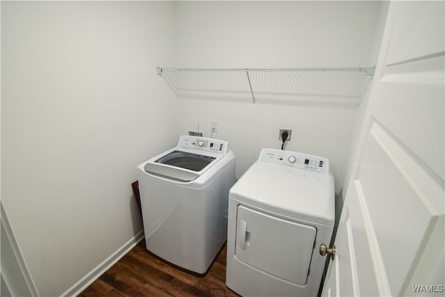 laundry area with washer and dryer and dark hardwood / wood-style flooring