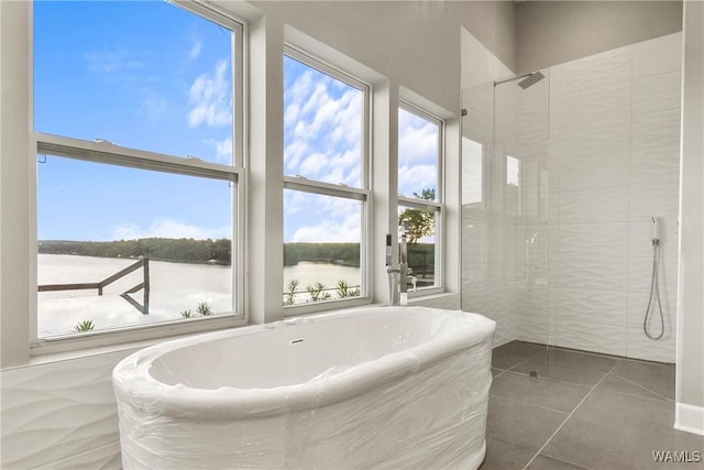 bathroom featuring tile patterned flooring, a water view, and shower with separate bathtub