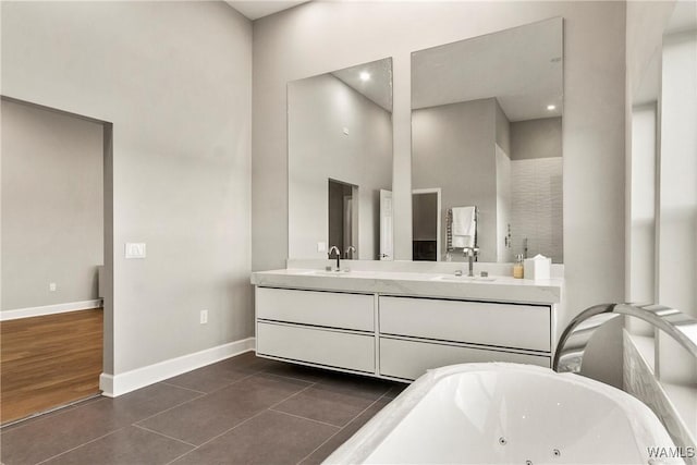 bathroom featuring tile patterned floors, vanity, a towering ceiling, and a tub