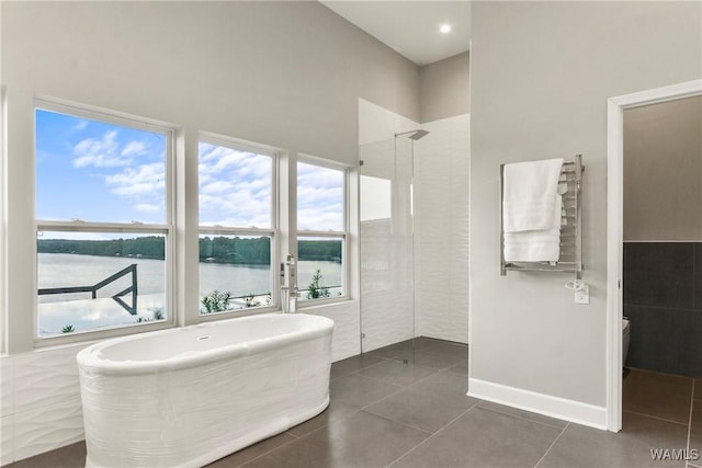 bathroom with radiator heating unit, tile patterned flooring, a water view, independent shower and bath, and tile walls