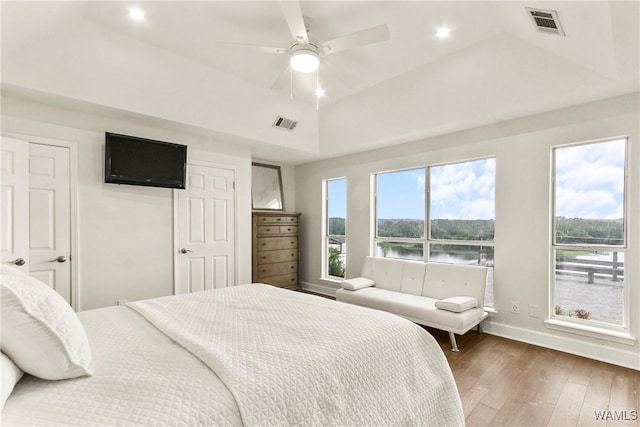 bedroom featuring a tray ceiling, ceiling fan, and dark wood-type flooring