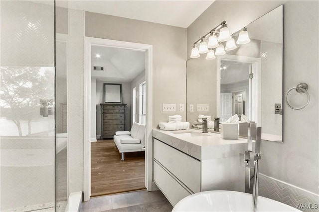 bathroom featuring a bathing tub, vanity, and wood-type flooring