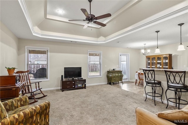 living room with plenty of natural light, a raised ceiling, a ceiling fan, and light colored carpet