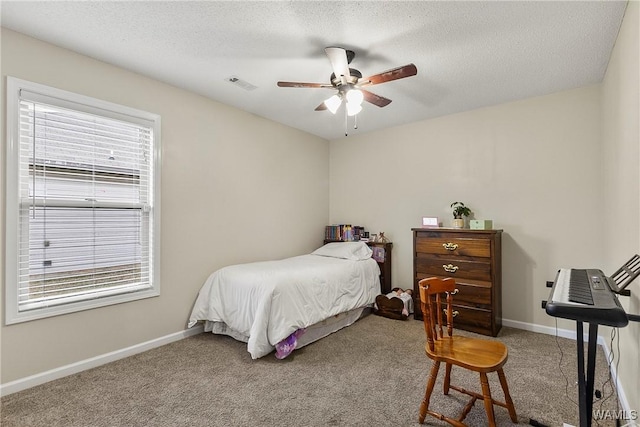 carpeted bedroom with visible vents, a textured ceiling, baseboards, and multiple windows