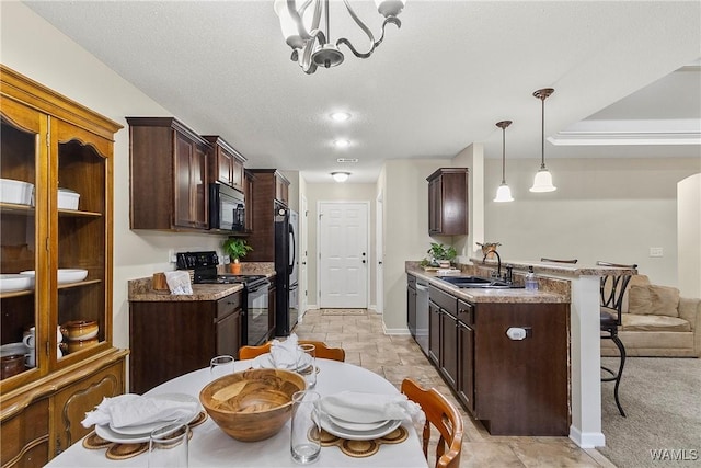 kitchen featuring a breakfast bar, dark brown cabinetry, and black appliances