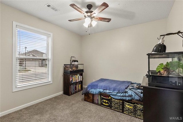 bedroom with carpet, a textured ceiling, visible vents, and baseboards