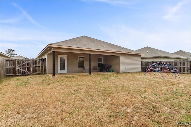 rear view of house with a patio, a lawn, and a fenced backyard