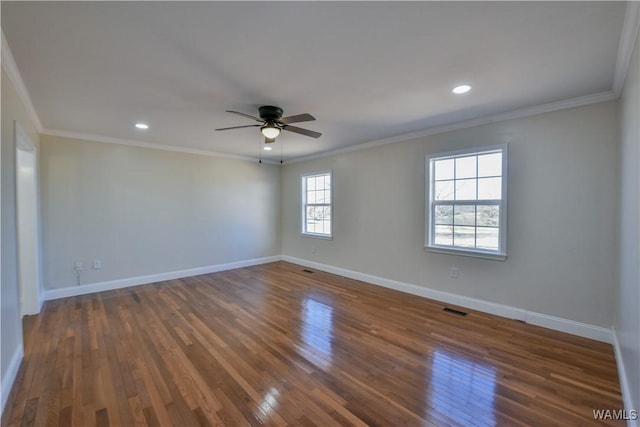 spare room with dark wood finished floors, crown molding, and baseboards