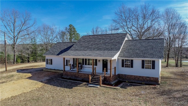 ranch-style house featuring covered porch, dirt driveway, crawl space, and roof with shingles