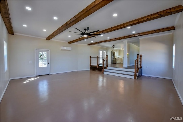 unfurnished living room with concrete flooring, a wealth of natural light, and baseboards