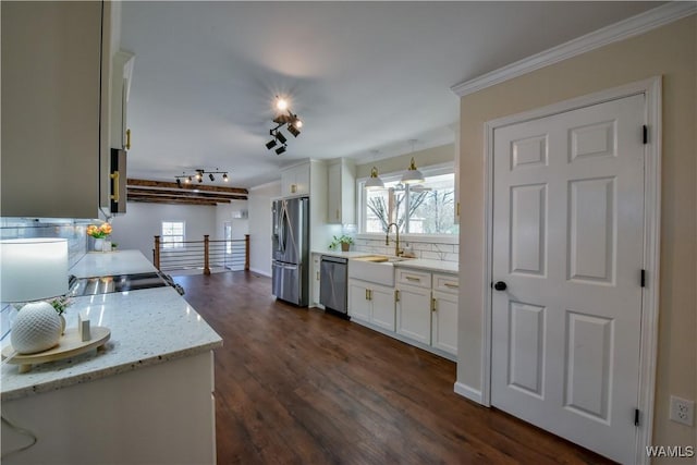 kitchen featuring dark wood finished floors, appliances with stainless steel finishes, a sink, and white cabinetry