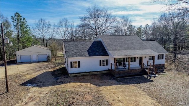 view of front facade with a garage, covered porch, roof with shingles, and an outdoor structure