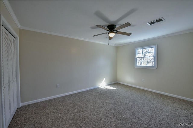 unfurnished bedroom featuring baseboards, visible vents, crown molding, and carpet flooring