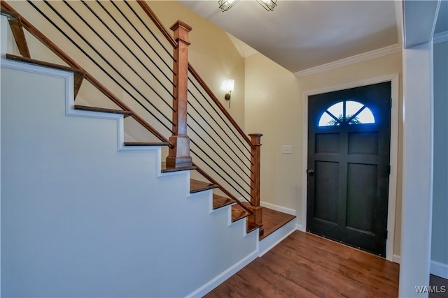 foyer featuring ornamental molding, stairway, wood finished floors, and baseboards