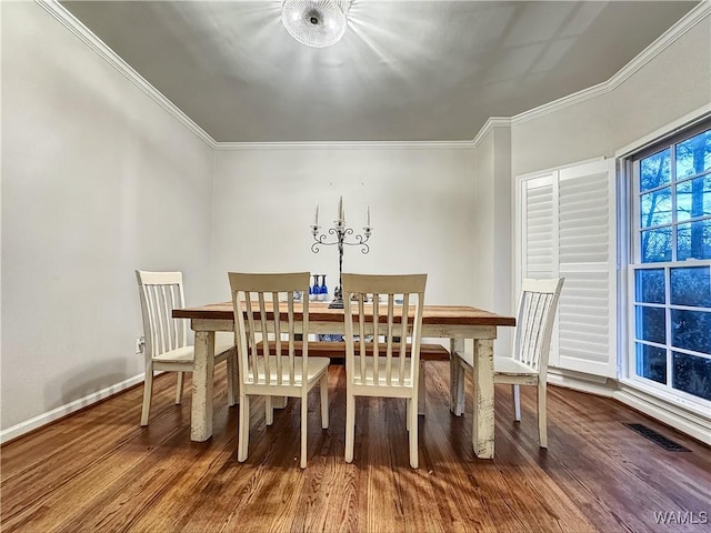 dining area featuring wood-type flooring and crown molding