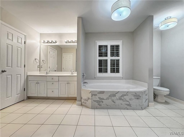 bathroom with vanity, tile patterned floors, tiled bath, and toilet