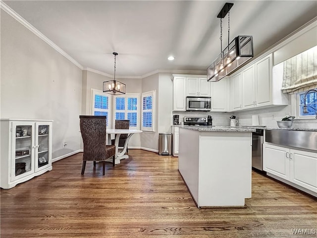 kitchen with white cabinetry, pendant lighting, stainless steel appliances, and hardwood / wood-style flooring