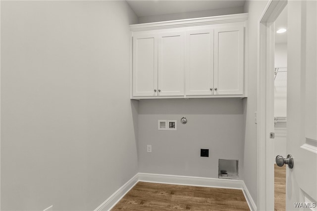 clothes washing area featuring electric dryer hookup, cabinets, gas dryer hookup, washer hookup, and dark hardwood / wood-style floors