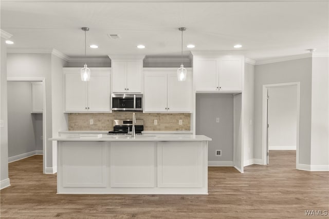 kitchen with appliances with stainless steel finishes, light hardwood / wood-style flooring, and a kitchen island with sink