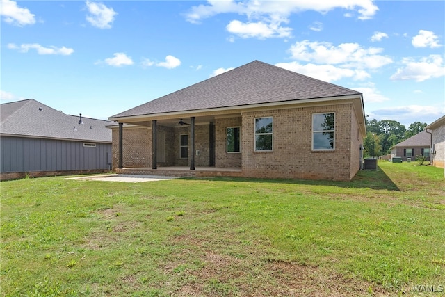 rear view of property featuring a yard, cooling unit, ceiling fan, and a patio area